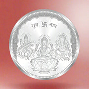 A silver coin with intricate designs including a depiction of the Hindu deities Ganesha and Saraswati.